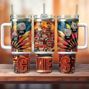 May include: A white stainless steel tumbler with a red, yellow, and blue design featuring a football team's logo and the years 1970, 2020, 2023, and 2024. The tumbler has a lid and a straw.