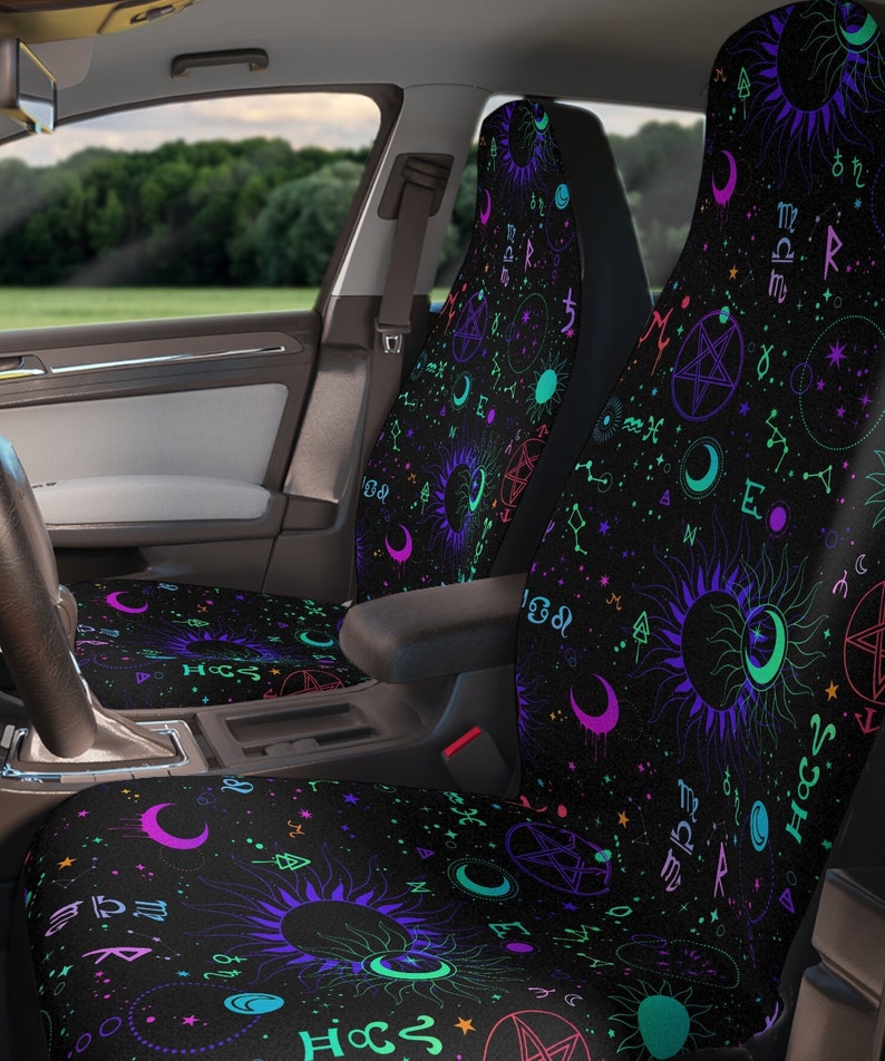 May include: Two black car seat covers with a colorful, psychedelic pattern of moons, suns, stars, and astrological symbols. The pattern is on a black background.
