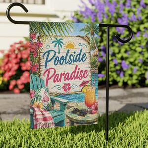 May include: A garden flag with the words "Poolside Paradise" on a wooden sign. The flag features a tropical scene with a chair, drink, and palm trees. The flag is displayed on a black metal stand in a grassy yard.