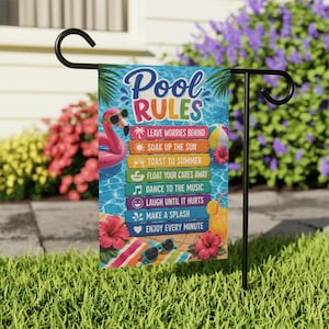 May include: A rectangular garden flag hanging on a black metal stand, featuring a blue swimming pool background with a pink flamingo float, sunglasses, and a tropical drink. The text reads Pool Rules with eight colorful horizontal wooden signs.