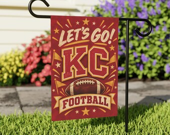 May include: A rectangular garden flag hanging on a black metal stand. The flag is red with yellow accents and features the text LET'S GO! KC FOOTBALL in bold lettering. A brown football graphic is centered below the letters with star motifs.