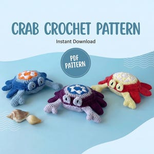 Può includere: Tre giocattoli a forma di granchio all'uncinetto in blu, viola e rosso con accenti bianchi e arancioni. L'immagine include il testo "CRAB CROCHET PATTERN" e "Instant Download" con un badge "PDF PATTERN". Due conchiglie sono nell'angolo in basso a sinistra.