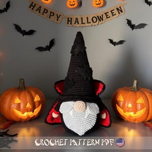May include: A crochet Halloween gnome with a black hat and cape, white beard, and red accents, flanked by two lit jack-o'-lanterns. The background features a "Happy Halloween" banner, bat cutouts, and pumpkin lights. The text "CROCHET PATTERN PDF" is at the bottom.