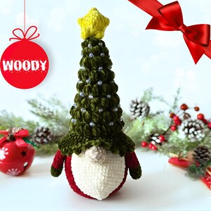 Può includere: Uno gnomo natalizio fatto a mano con un corpo verde a forma di albero, adornato con perline d'argento e una stella gialla. Lo gnomo ha barba bianca, cappello e corpo rossi, e la parola "WOODY" su una palla rossa.