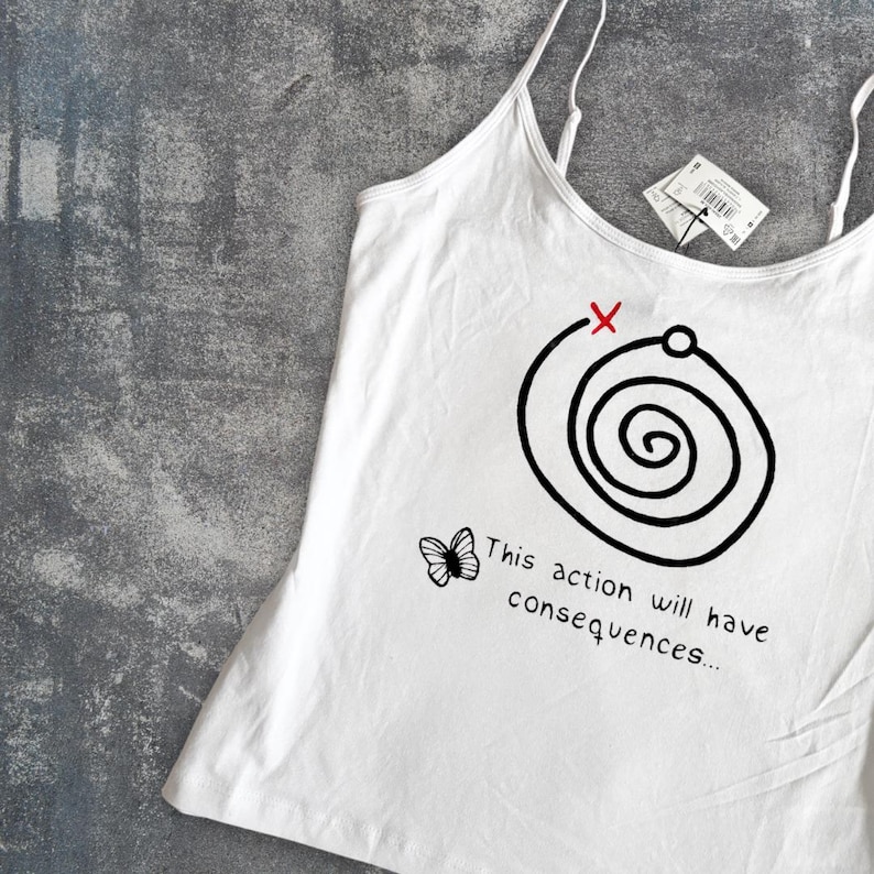 May include: White camisole with thin straps featuring a black spiral design with a red X and the text "This action will have consequences...". A small butterfly graphic is also present. A tag is attached.