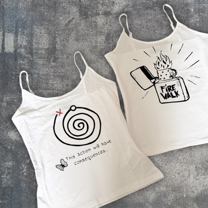 May include: Two white tank tops with black graphic designs. One features a spiral with the text "This action will have consequences..." and a butterfly. The other has a lighter with the text "Fire Walk".