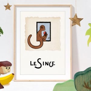 May include: Framed art print featuring a brown monkey holding a red fruit, set against a light blue background within a black-lined window. The text "LE SINGE" is below the image. Decorative wooden stars and a wooden monkey toy are also visible.