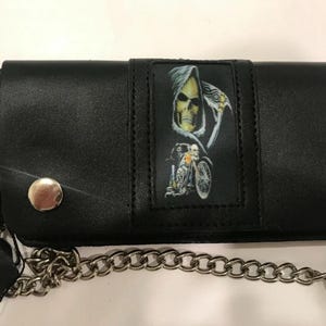 May include: Black leather wallet with a chain and a skull graphic. The skull is riding a motorcycle and has a scythe.