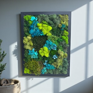 May include: A rectangular wall art piece featuring a vibrant arrangement of preserved moss. The artwork showcases a variety of textures and shades, including bright green, teal, and dark green moss, all set within a black frame. The piece adds a natural, organic element to any space.