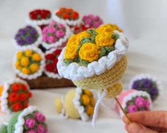 Puede incluir: Una colección de ramos de flores de ganchillo en varios colores, incluyendo amarillo, rosa, morado y rojo. Los ramos están dispuestos en una cesta y están hechos con una variedad de puntadas y texturas.