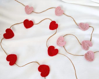 May include: A string of crocheted hearts in pink and red, strung on twine, perfect for Valentine's Day decor.