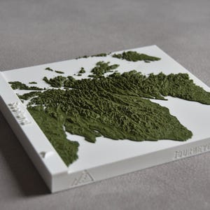 May include: A white 3D printed map of a mountainous region, with green textured details. The map is titled "Four Way Graph".