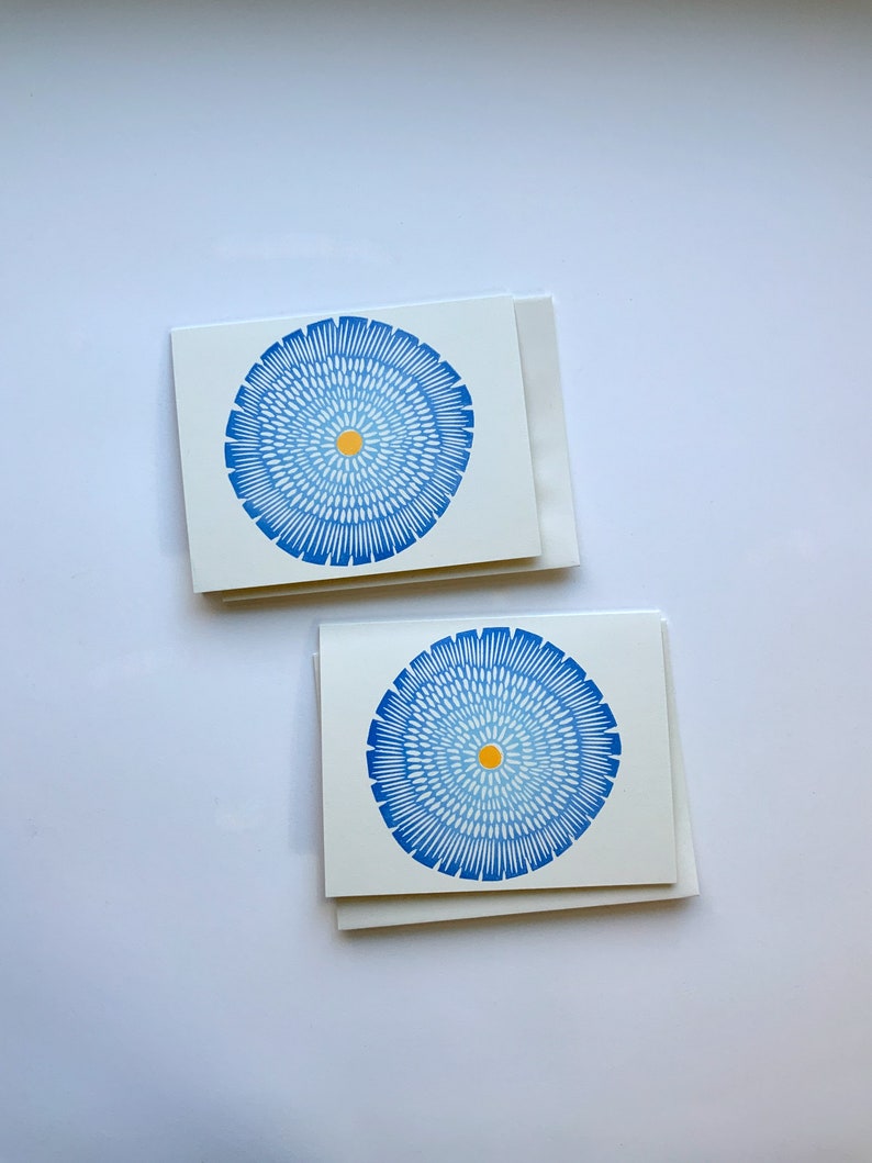 Op de afbeelding: Twee blanco wenskaarten met blauwe en gele cirkelvormige ontwerpen. De kaarten liggen op elkaar.