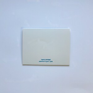 Op de afbeelding: Witte kaart met blauwe tekst die "hand painted" en "leannemccue.com" zegt