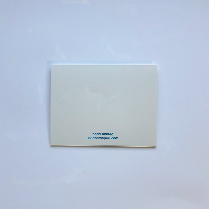 Op de afbeelding: Witte kaart met blauwe tekst die "hand painted" en "leannemccue.com" zegt