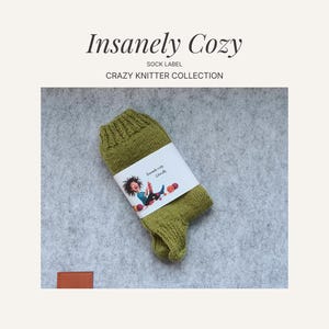 Op de afbeelding: Een olijfgroene gebreide sok met een wit etiket met een cartoon illustratie. Het etiket leest "Insanely Cozy" en "Crazy Knitter Collection". De sok wordt gepresenteerd op een grijs, getextureerd oppervlak.