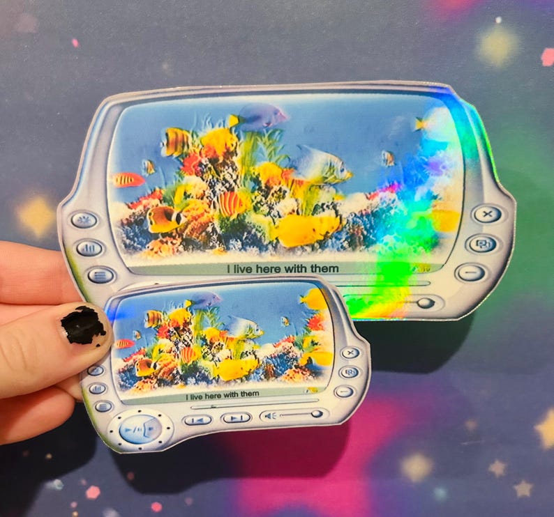 May include: Two holographic stickers of a computer screen displaying a fish tank screensaver. The text on the screen reads "I live here with them".