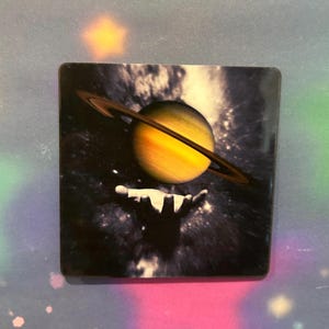 Space hand holding Saturn sticker
