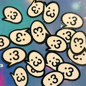 Puede incluir: Una colección de pegatinas de burbujas de diálogo blancas con un contorno negro y el texto ":3" en su interior. Las pegatinas están sobre un fondo azul.
