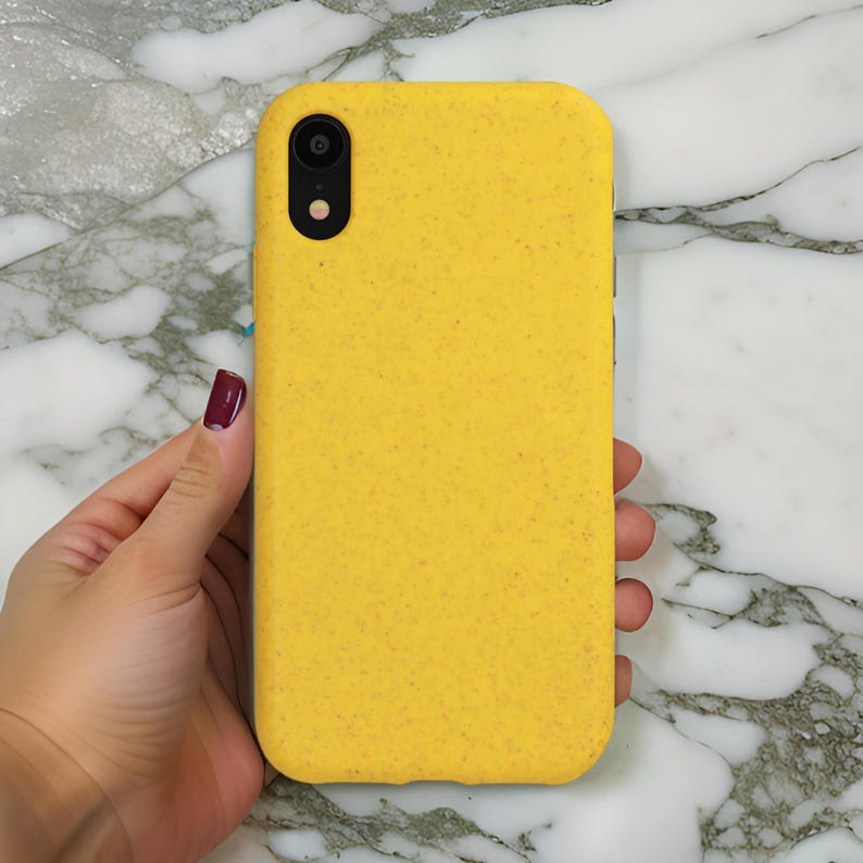Op de afbeelding: Een gele telefoonhoes van gerecyclede materialen. De hoes heeft een textuur en een zwarte uitsparing voor de camera.