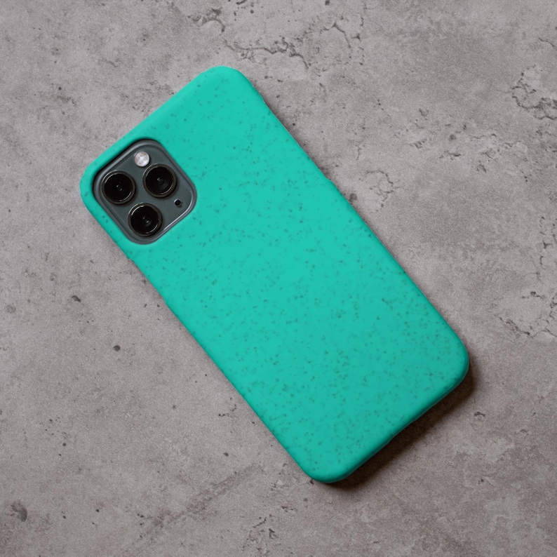 Puede incluir: Una funda de tel&eacute;fono turquesa con una textura moteada, dise&ntilde;ada para un tel&eacute;fono inteligente. La funda tiene un recorte para la c&aacute;mara y un dise&ntilde;o suave y redondeado. La funda est&aacute; hecha de un material duradero.
