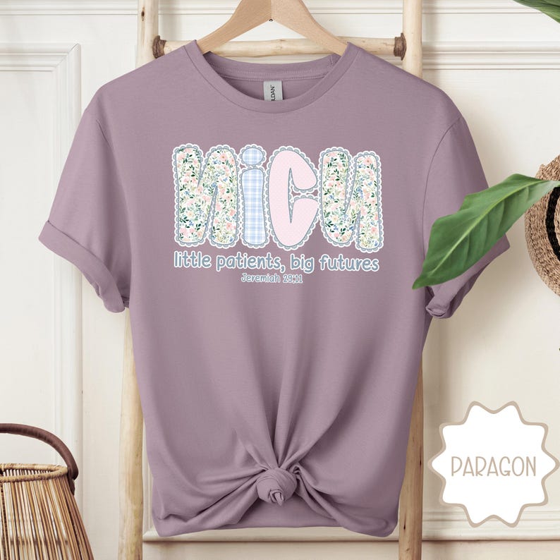 May include: A lilac t-shirt featuring the word "MICU" in a floral and gingham pattern. The text "little patients, big futures" and a Bible verse are printed below. The shirt is knotted at the waist.