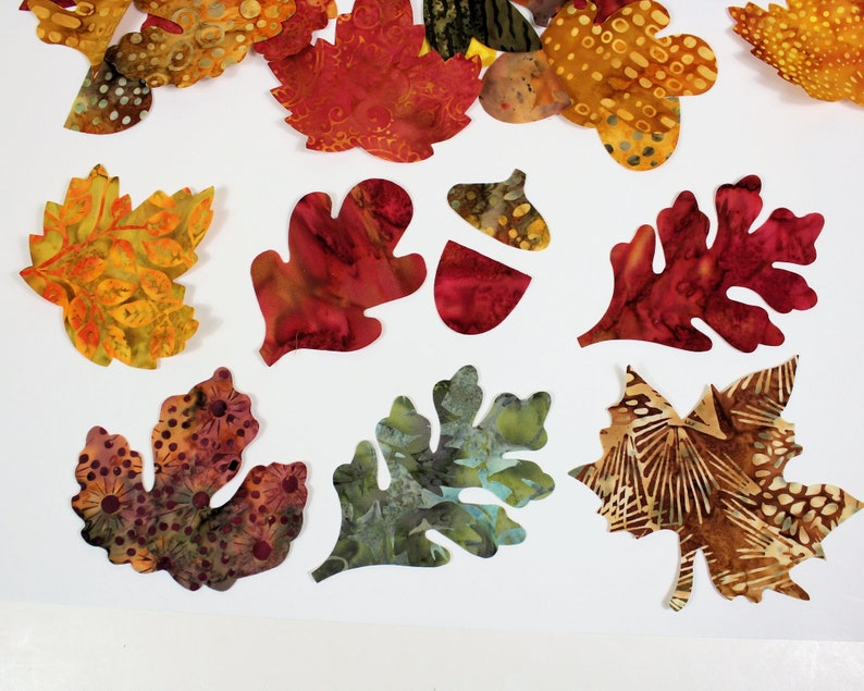 Small autumn leaves made of cotton batik fabric with fusible adhesive already on the back.  These are from 2" to 4" long and in beautiful fall colors of rust, brown, gold, green.  Includes acorns, maple and oak leaves.