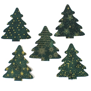 May include: Five Christmas tree-shaped fabric cutouts in various patterns. The trees are primarily dark green with gold accents, including stars, snowflakes, and other festive designs. The cutouts are arranged on a white background.