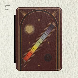 May include: A dark brown e-reader case featuring a gold-lined archway design, a sun icon, small stars, and a diagonal spectrum bar transitioning from red to violet. The text "The Case Exhibit" is printed in the top left corner of the cover.