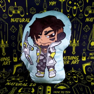 May include: A light blue plush pillow with a cartoon character on it. The character is a person with brown hair, wearing a white jacket with yellow accents, black pants, and white shoes. The character is holding a white and blue weapon. The pillow has the text "Something for Art" on it.