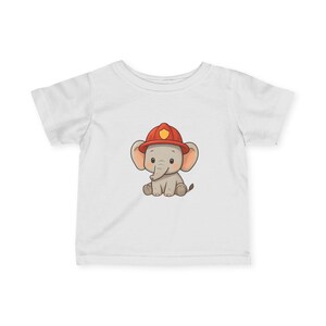 May include: White t-shirt featuring a cartoon elephant wearing a red firefighter helmet. The elephant is gray with large ears and a trunk. The helmet has a yellow emblem. The design is centered on the shirt.