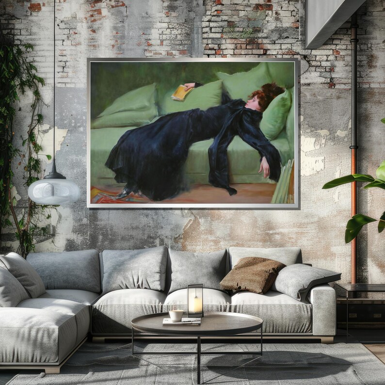 May include: A painting of a woman in a black dress lying on a green couch. She is holding a book in her hand and her head is resting on a pillow. The painting is framed in a silver frame.