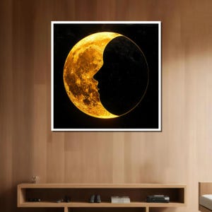 May include: A crescent moon with a human face silhouette in the center, against a black background. The moon is a bright, golden yellow color.
