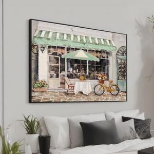 Könnte beinhalten: Gerahmtes Gemälde, das eine charmante Cafészene darstellt. Das Kunstwerk zeigt ein Gebäude mit einer grün-weiß gestreiften Markise, einen Tisch mit weißer Tischdecke, ein gelbes Fahrrad mit einem Blumenkorb und einen roten Stuhl. Der Stil ist impressionistisch.