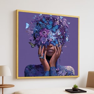 May include: A framed art print featuring a woman with a floral and butterfly headdress. The artwork showcases a vibrant color palette of purples and blues, with a gold frame. The woman's hands are raised near her face.