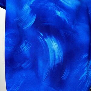 May include: Blue fabric with a white abstract brushstroke pattern.