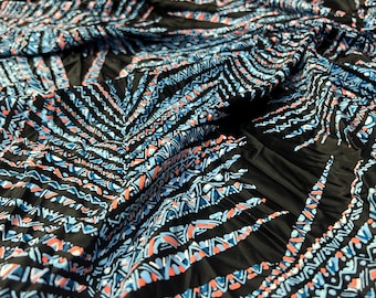 May include: Black fabric with a blue and pink geometric pattern. The pattern is made up of repeating triangles and lines.