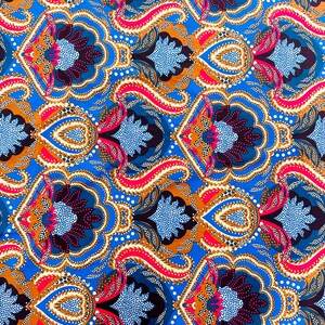May include: Vibrant fabric with a repeating pattern of stylized floral and paisley elements. The design features a bright blue background with accents of orange, red, and dark blue. White polka dots add detail to the overall design.