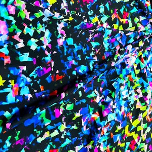 Puede incluir: Tela negra con un patrón abstracto vibrante. El diseño presenta formas irregulares en tonos de azul, verde, rosa, amarillo y rojo, creando un efecto colorido similar a confeti. Adecuado para ropa o decoración del hogar.