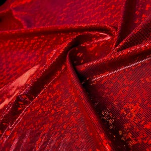 May include: Red metallic fabric with a small, repeating pattern. The fabric has a shiny, iridescent finish.