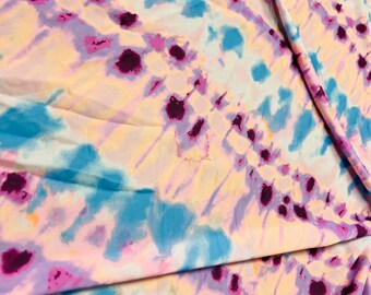 May include: A tie-dye fabric with a swirl pattern in shades of pink, blue, and purple.