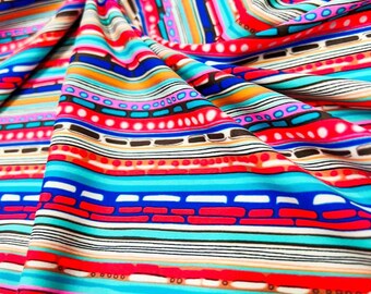 Könnte beinhalten: Ein lebendiger Stoff mit einem farbenfrohen Streifenmuster. Das Design zeigt horizontale und vertikale Streifen in Rot-, Blau-, Türkis-, Orange- und Schwarztönen. Der Stoff ist gefaltet und zeigt die Textur und den Fluss des Materials.