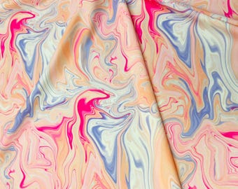 May include: A fabric with a swirling, marbled pattern in shades of pink, blue, and cream. The fabric is smooth and silky, with a soft, flowing texture.