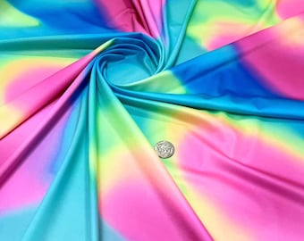 May include: Vibrant fabric with a colorful, abstract design. The fabric features a blend of pink, blue, yellow, and green hues, creating a tie-dye or watercolor effect. The fabric is smooth and appears to be a lightweight material, suitable for apparel or crafts.