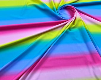 May include: A colorful fabric with a rainbow ombre stripe pattern. The fabric is folded and twisted, showing the different colors of the stripes.