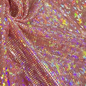 Puede incluir: Primer plano de una tela rosa brillante con un patrón texturizado en forma de escamas. La tela está drapeada, creando pliegues y sombras. Lentejuelas iridiscentes están dispersas por la superficie, reflejando un arcoíris de colores.