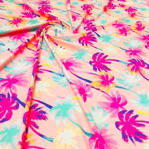 以下が含まれることがあります： ピンクの生地に、カラフルなヤシの木が繰り返し描かれたパターン。木はピンク、ブルー、イエロー、グリーンのグラデーションで描かれています。
