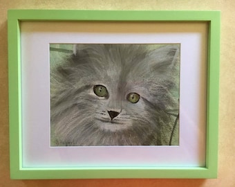 May include: A framed artwork featuring a close-up of a fluffy gray cat with bright green eyes. The cat's fur is detailed, and the artwork is set within a white mat and a light green frame. Signed by B.Hubert.