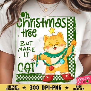 Könnte beinhalten: Weißes T-Shirt mit einem weihnachtlichen Motiv. Das Design zeigt eine Cartoon-Katze, die als Weihnachtsbaum geschmückt ist, mit dem Text "Oh Christmas tree BUT MAKE IT CAT". Die Katze trägt einen Stern und rote Stiefel.