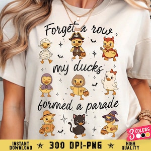 Pode incluir: Camiseta creme com um gráfico temático de Halloween. O design inclui patos de desenho animado fantasiados, morcegos e o texto "Forget a row, my ducks formed a parade." O texto adicional inclui "Instant Download" e "300 DPI-PNG."